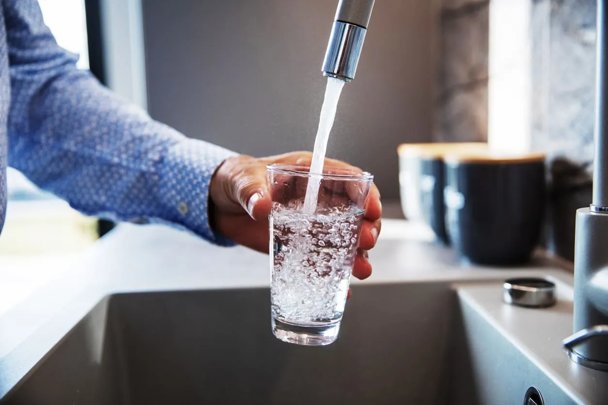 Pouring Water Into a Glass from Kitchen Faucet