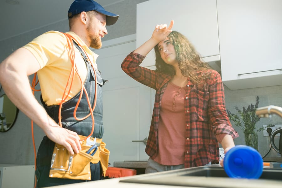 Plumber helping a homework with a kitchen sink clog.