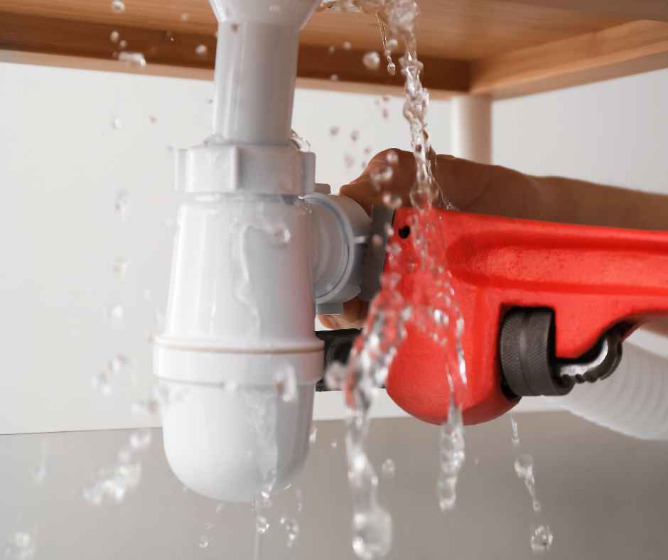 A plumber fixing a leak with his tools